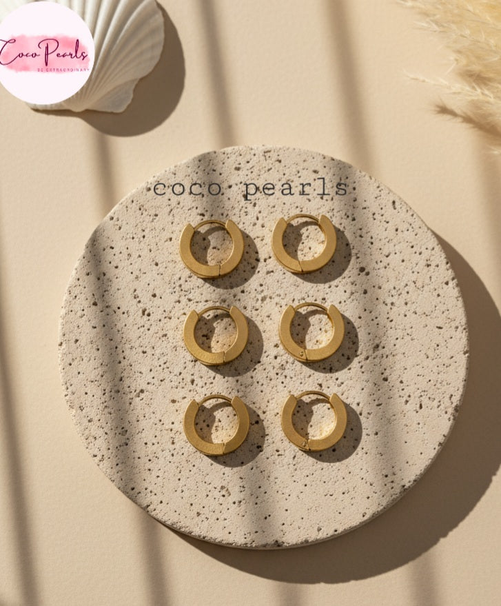 Coco Pearls Stainless Steel Anti Tarnish Golden barrel hoop earrings on a beige stone surface