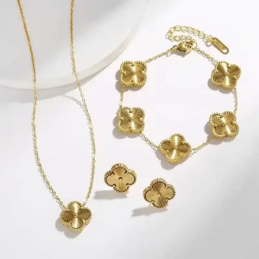 Coco Pearls Stainless Steel Anti Tarnish Golden clover jewelry set with golden clover necklace, bracelet, and earrings on a white background