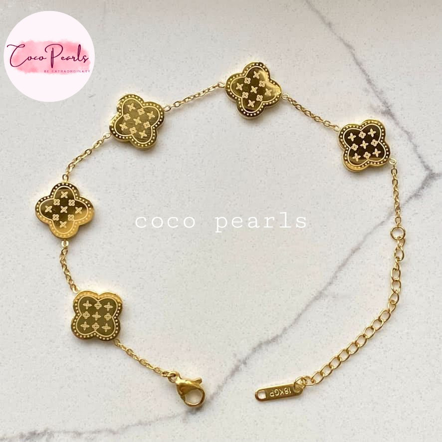 Coco Pearls Stainless steel Anti Tarnish Golden fortune bracelet with clover-shaped charms on a marble surface