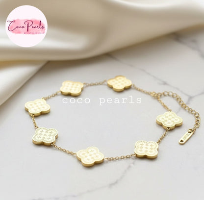 Coco Pearls Stainless steel Anti Tarnish Golden fortune bracelet with clover-shaped charms on a marble surface