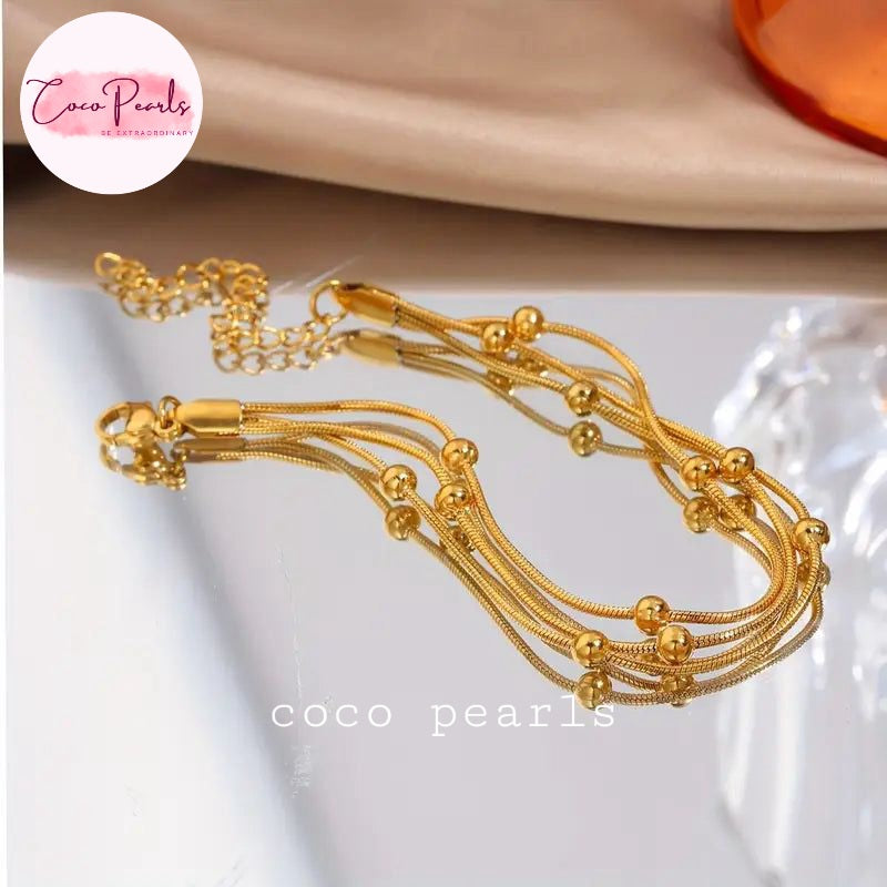 Coco Pearls Stainless steel Anti Tarnish Golden harmony bracelet  with 3 layer ball chain on a white surface