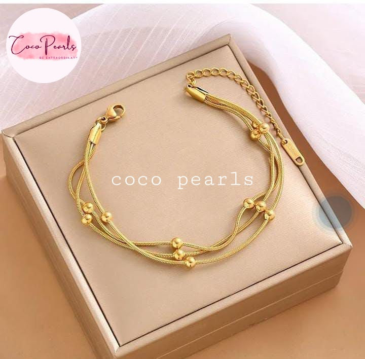 Coco Pearls Stainless steel Anti Tarnish Golden harmony bracelet 3 layer ball chain on a beige box