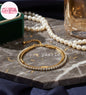 Coco Pearls Stainless steel Anti Tarnish Golden stream link bracelet with double layer chain. a diamond studded line and golden chain displayed on a marble surface with pearls and a glass.