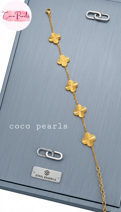 coco pearls stainless steel jewelry pakistan anti tarnish waterproof gold essence clover bracelet displayed on metallic background