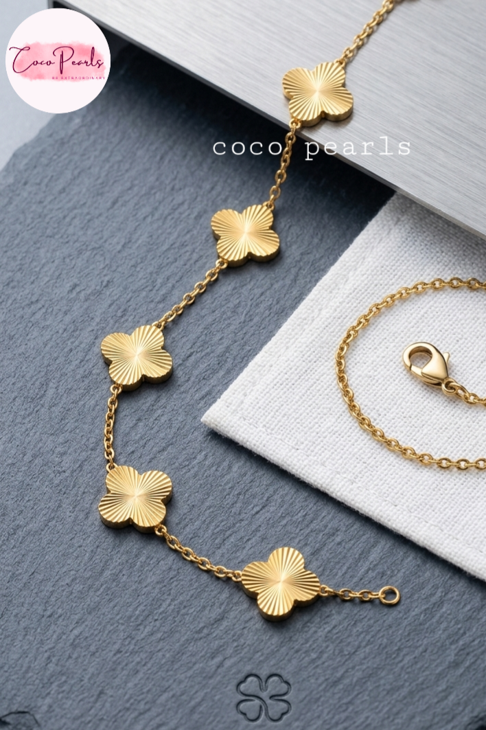 coco pearls stainless steel jewelry pakistan anti tarnish waterproof gold essence clover with golden clovers bracelet displayed on metallic background