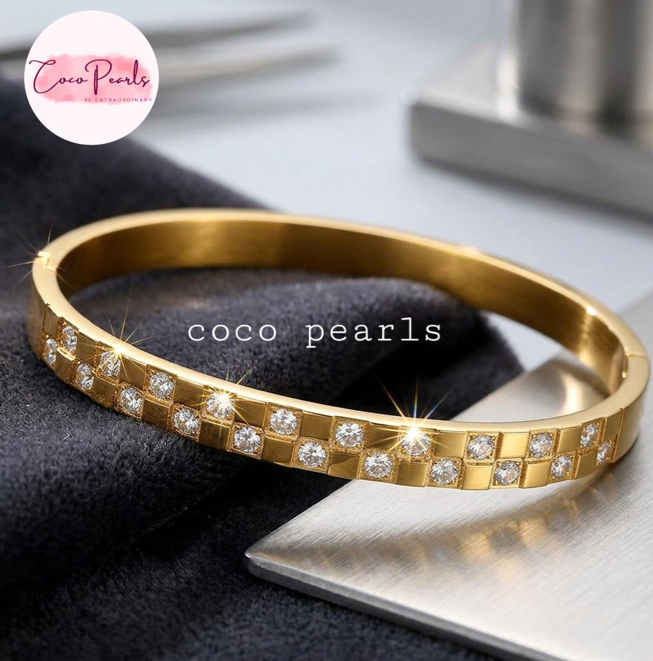 Coco Pearls Stainless Steel Anti tarnish gold grid spark handcuff with diamond grid design on marble surface