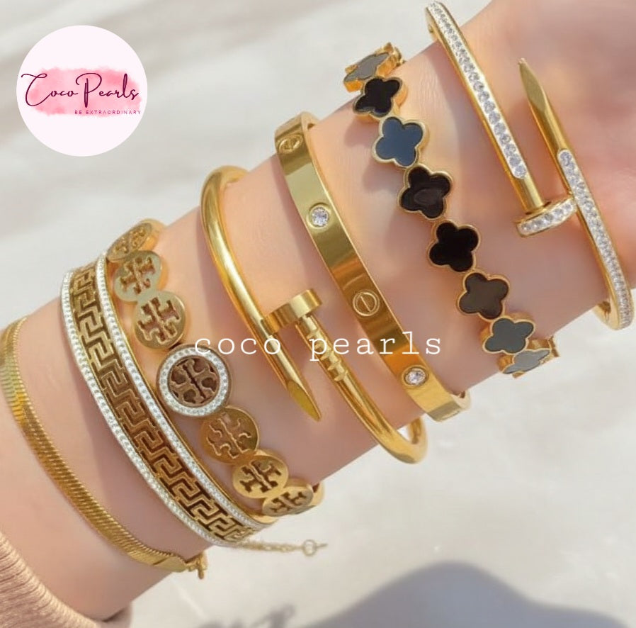 Coco Pearls Stainless steel Anti tarnish Collection of gold handcuff bangle bracelets on a hand