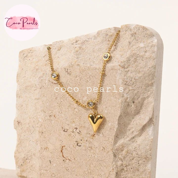 Coco Pearls Stainless Steel Anti Tarnish Gold heartbeat anklet with a heart pendant on a stone surface