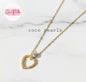Coco Pearls Stainless Steel Anti Tarnish Gold heart sparkle necklace. heart-shaped pendant necklace with a diamond on a marble background