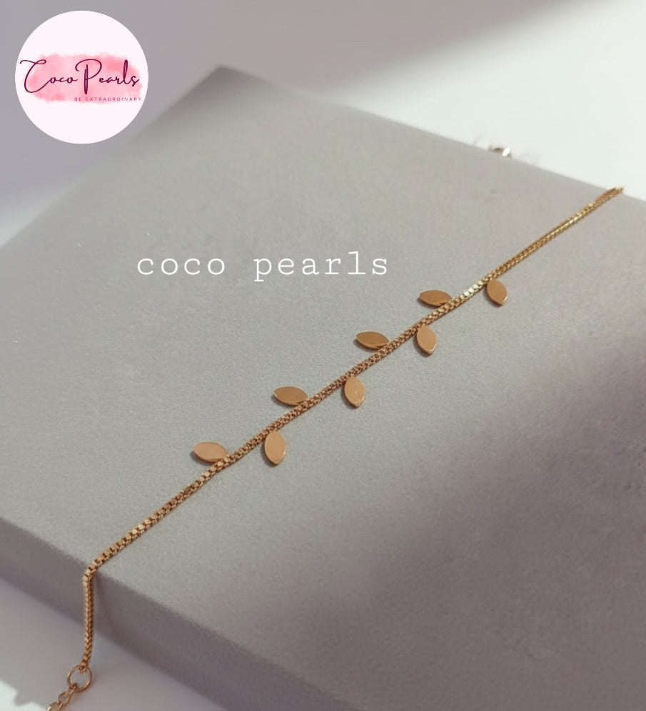 Coco Pearls Stainless steel Anti tarnish Gold leafy bracelet with leaf-shaped charms on a gray surface