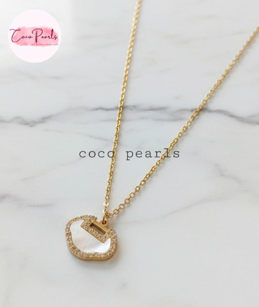 Coco Pearls Stainless Steel Anti Tarnish Gold loop glam necklace with a white irregular circular pendant on a marble background