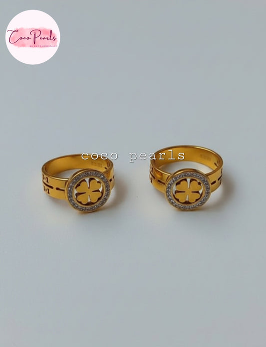 Coco Pearls Stainless Steel Anti Tarnish Gold luck charm ring with gemstones studded clover charm on a gold band on a marble surface