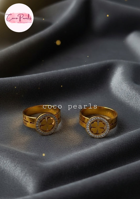 Coco Pearls Stainless Steel Anti Tarnish Gold luck charm ring with gemstones studded clover charm on a gold band on a black background 