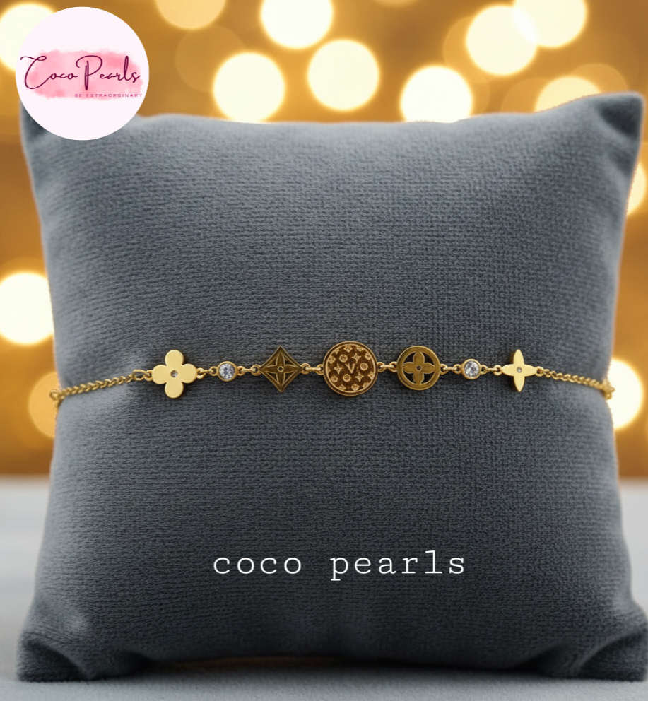 coco pearls stainless steel anti tarnish Gold lucky charm bracelet with intricate designs on a dark background