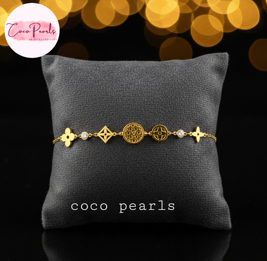 coco pearls stainless steel anti tarnish Gold lucky charm bracelet with intricate designs on a pillow