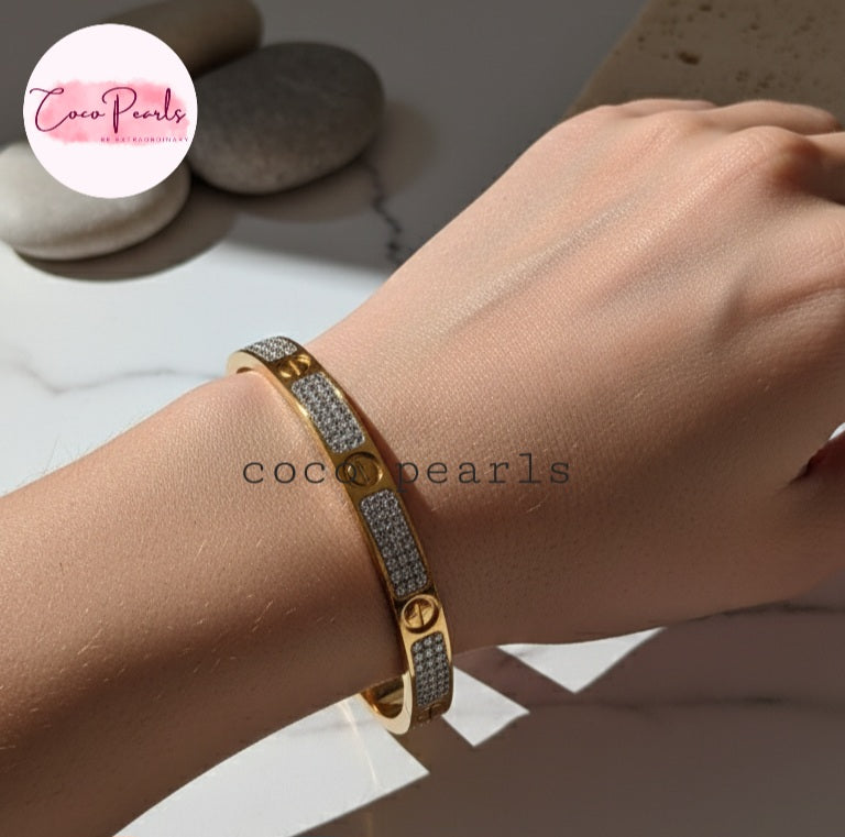 Coco Pearls Stainless Steel Anti Tarnish Gold lucky charm handcuff bangle bracelet with gemstones on a wrist