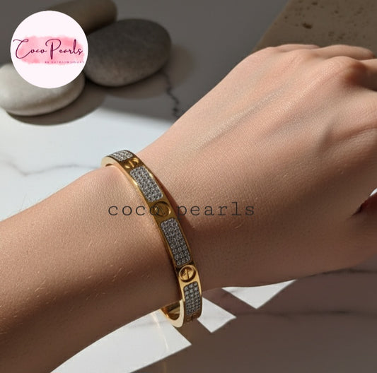Coco Pearls Stainless Steel Anti Tarnish Gold lucky charm handcuff bangle bracelet with gemstones on a wrist