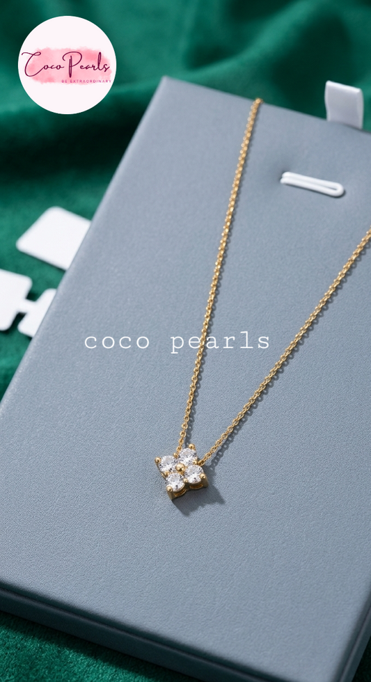 coco pearls stainless steel jewelry pakistan anti tarnish waterproof gold lucky four clover shaped diamond studded necklace displayed on alight background