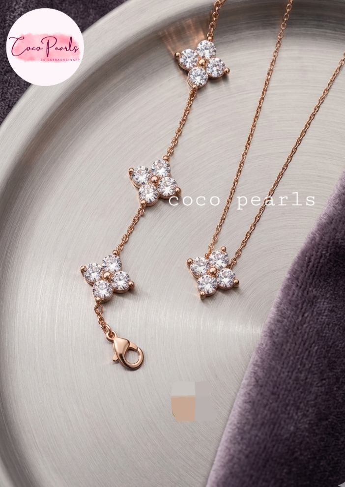 coco pearls stainless steel jewelry pakistan anti tarnish waterproof gold lucky four clover shaped diamond studded bracelet and necklace displayed on alight background