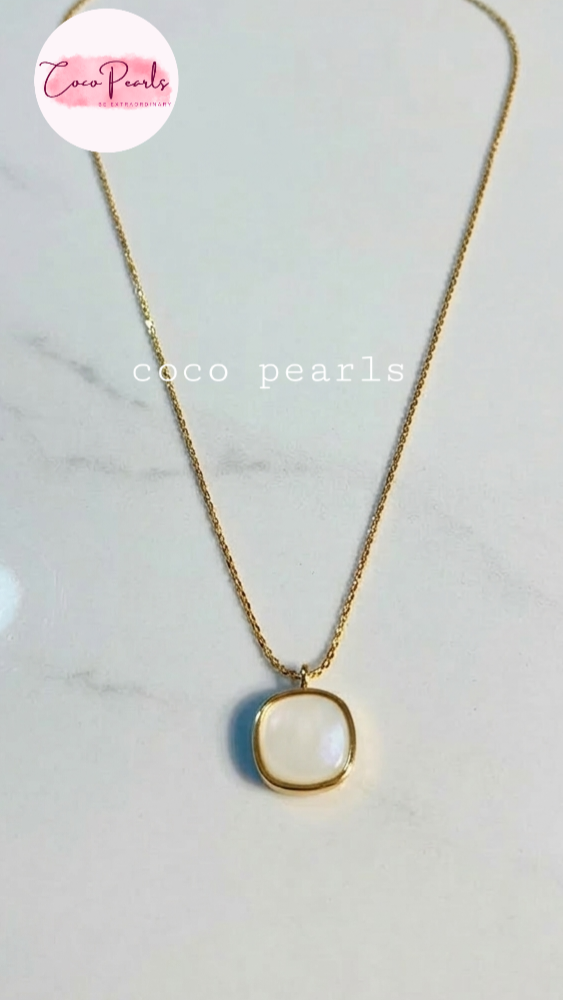 Coco Pearls Stainless Steel Anti Tarnish luminous drop Gold necklace with a white pendant on a white surface