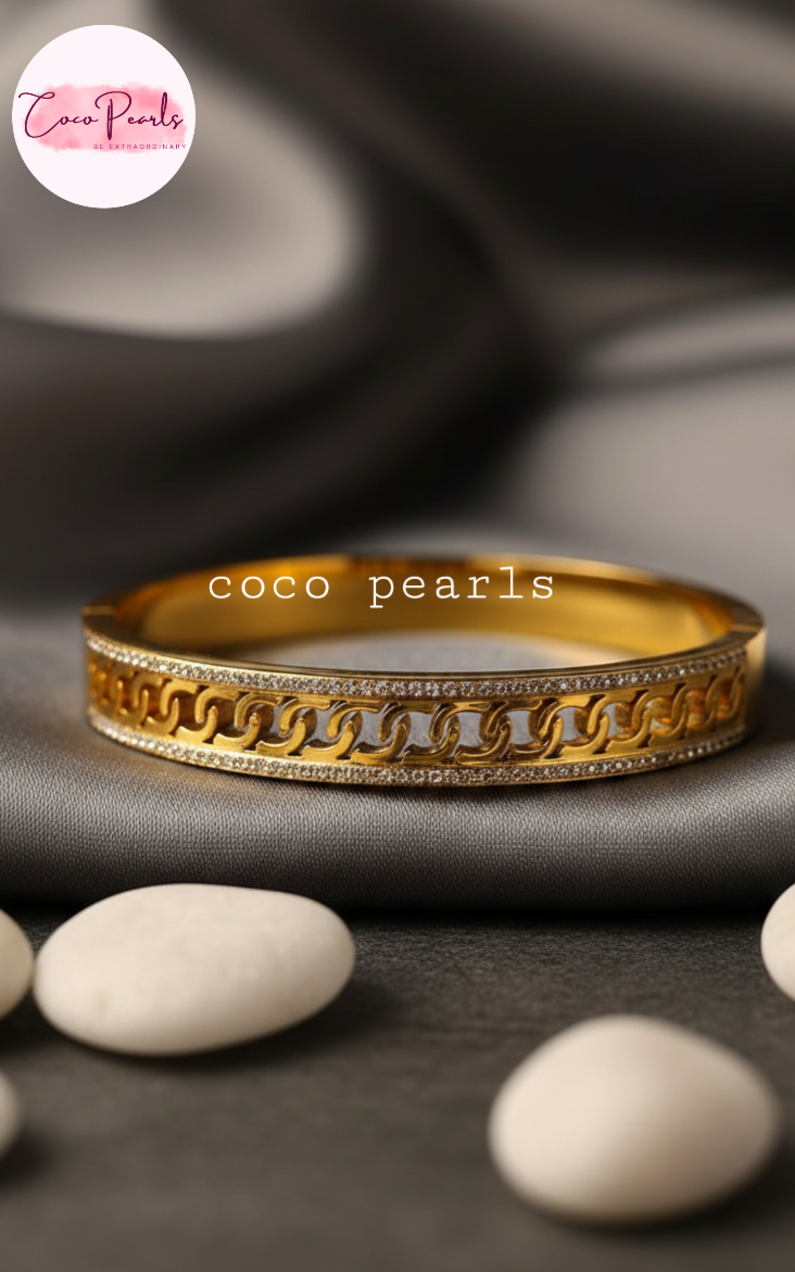 coco pearls stainless steel anti tarnish Gold luxury chai bangle handcuff diamond studded displayed on a dark surface