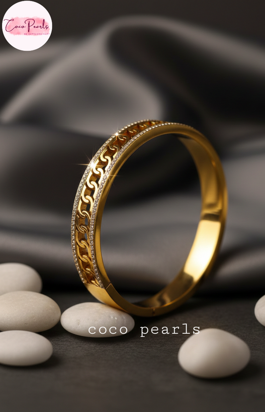 coco pearls stainless steel anti tarnish Gold luxury chai bangle handcuff diamond studded intricate design on a dark fabric background