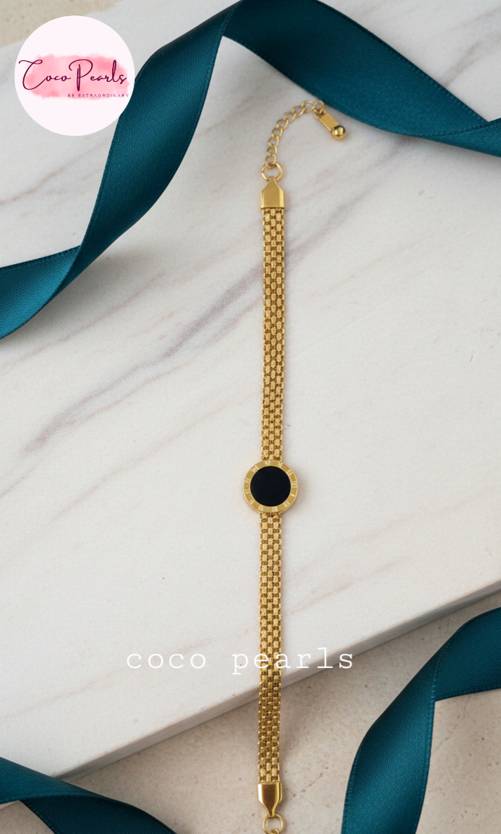 stainless steel anti tarnish Gold midnight aura bracelet with a black circle on a wrist