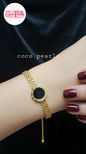 stainless steel anti tarnish Gold midnight aura bracelet with a black circle on a wrist