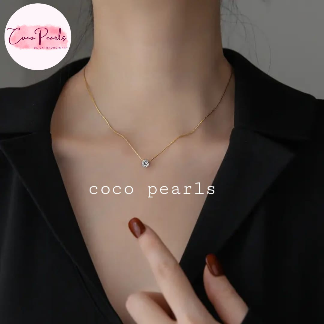 Coco Pearls Stainless Steel Anti Tarnish Gold milestone necklace with a small clear stone pendant on a person's neck