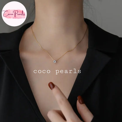 Coco Pearls Stainless Steel Anti Tarnish Gold milestone necklace with a small clear stone pendant on a person's neck