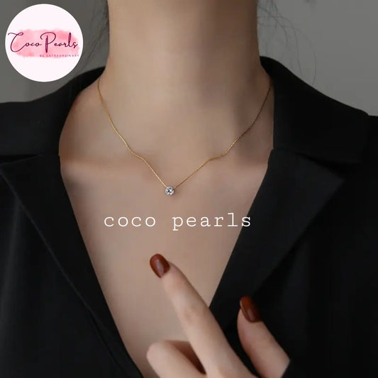 Coco Pearls Stainless Steel Anti Tarnish Gold milestone necklace with a small clear stone pendant on a person's neck