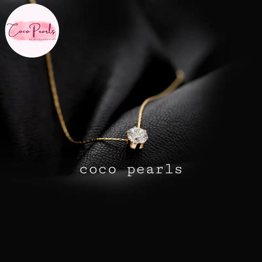 Coco Pearls Stainless Steel Anti Tarnish Gold milestone necklace with a diamond pendant on a black background