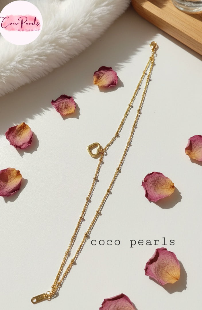 Coco Pearls Stainless Steel Anti Tarnish Gold minimal love anklet  with heart-shaped pendant on a light surface with pink petals