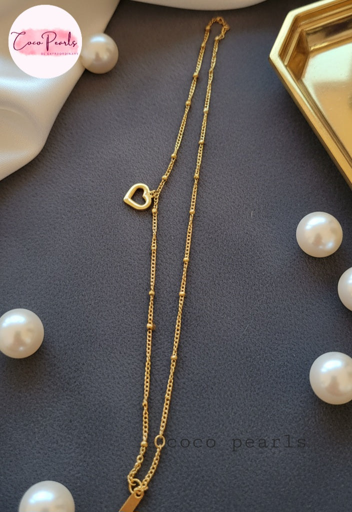 Coco Pearls Stainless Steel Anti Tarnish Gold minimal love anklet with a heart pendant on a dark surface surrounded by pearls