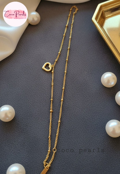 Coco Pearls Stainless Steel Anti Tarnish Gold minimal love anklet with a heart pendant on a dark surface surrounded by pearls