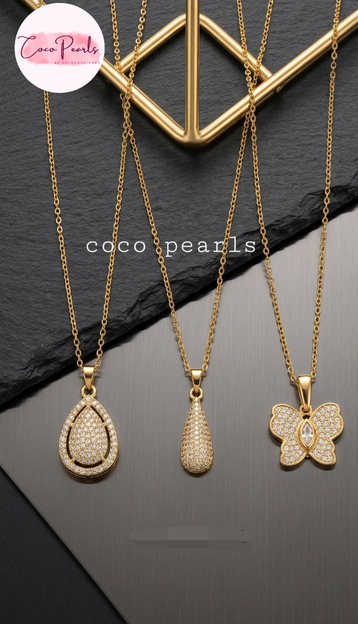 coco pearls stainless steel pakistan anti tarnish waterproof Three gold necklaces with pendants on a dark surface