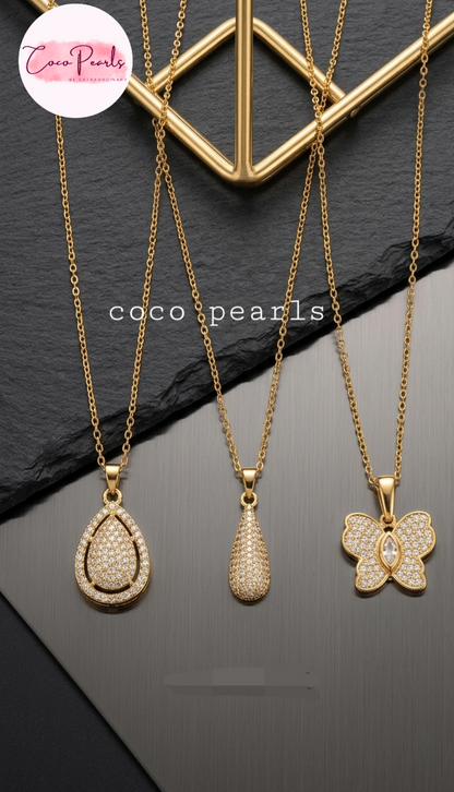 coco pearls stainless steel pakistan anti tarnish waterproof Three gold necklaces with pendants on a dark surface
