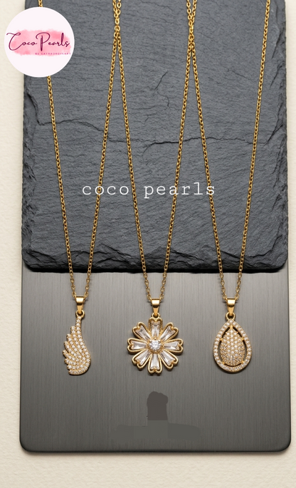 coco pearls stainless steel pakistan anti tarnish waterproof Three gold necklaces with pendants on a dark surface