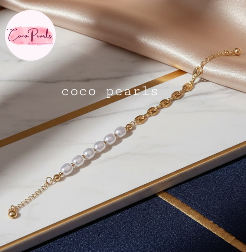 Coco Pearls Stainless Steel Anti Tarnish Pearl cascade bracelet with gold chain  and pearls on a marble surface