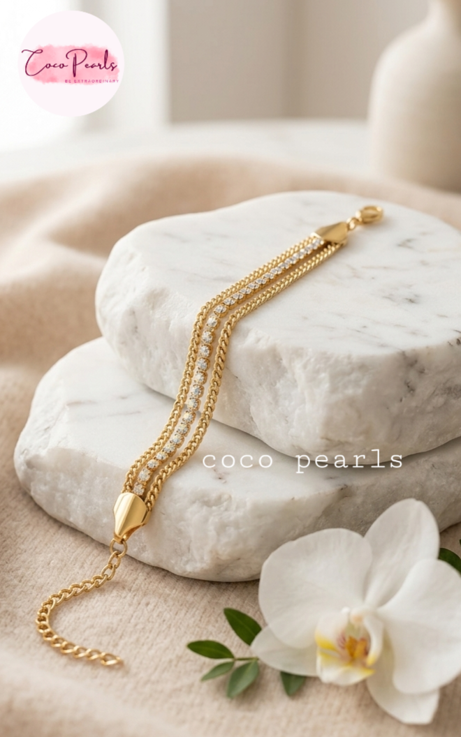 Coco Pearls Stainless Steel Anti tarnish gold radiant river bracelet. 3 layer stack bracelet with diamond studded line with chain on both side displayed on white background.