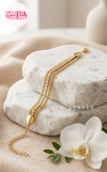 Coco Pearls Stainless Steel Anti tarnish gold radiant river bracelet. 3 layer stack bracelet with diamond studded line with chain on both side displayed on white background.