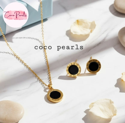 Coco Pearls Stainless Steel Anti Tarnish Gold roman set necklace and earrings with black stones and numerals on a white surface