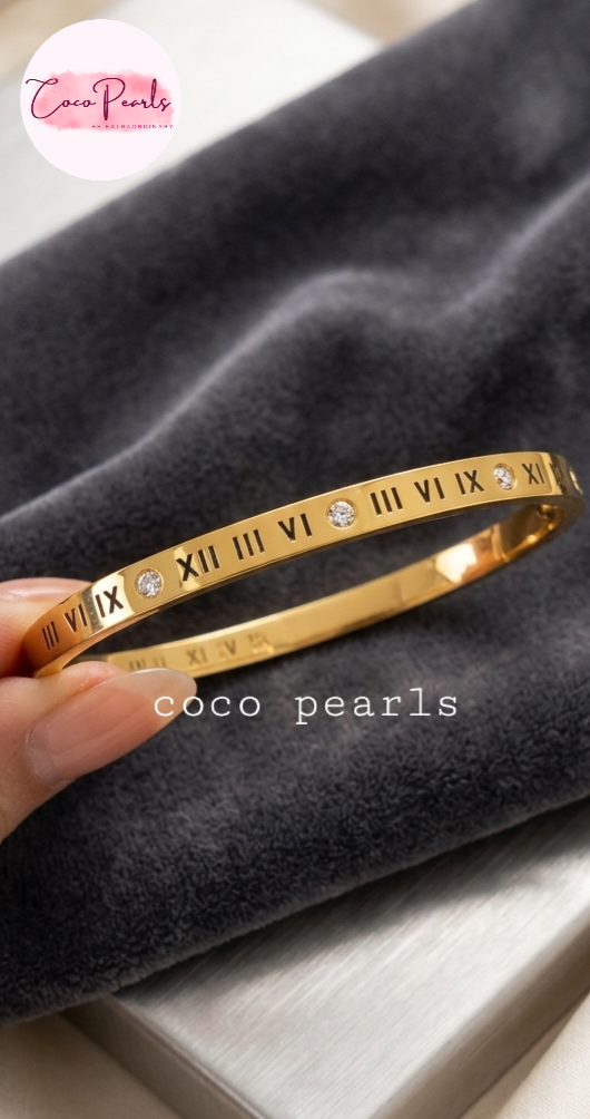 Coco Pearls Stainless Steel Anti Tarnish Gold roman handcuff bangles with Roman numeral design on a wooden surface