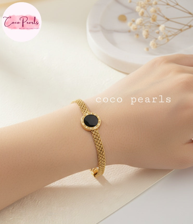 Coco Pearls Stainless steel Ani Tarnish Gold roman fake watch mesh bracelet with a black fake watch center on a wrist