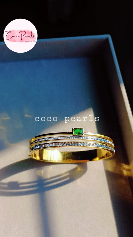coco pearls stainless steel anti tarnish gold royal emerald diamond handcuff bangle bracelet with rhinestones and emerald in center displayed in box