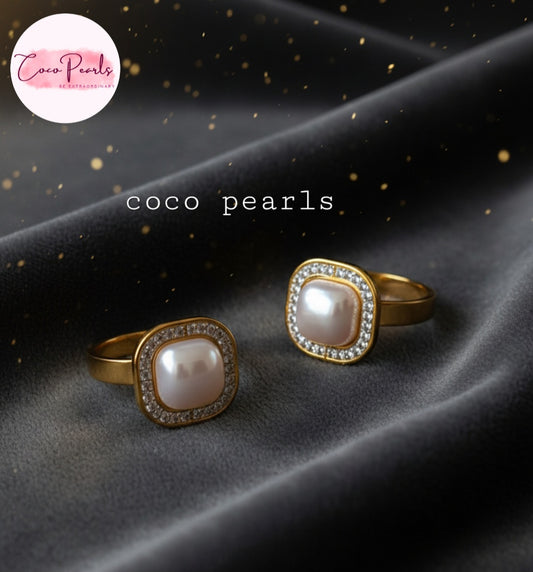 Coco Pearls Stainless Steel Anti Tarnish Gold royal pearl rings with diamond studded square shaped pearl displayed on a black fabric