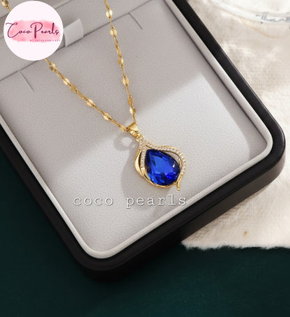 coco pearls stainless steel anti tarnish Gold sapphire tear drop necklace with a sapphire blue teardrop pendant on a jewelry box