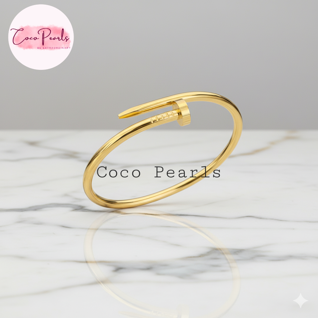 Coco Pearls Stainless Steel Anti Tarnish Gold sleek nail handcuff bracelet on a marble surface