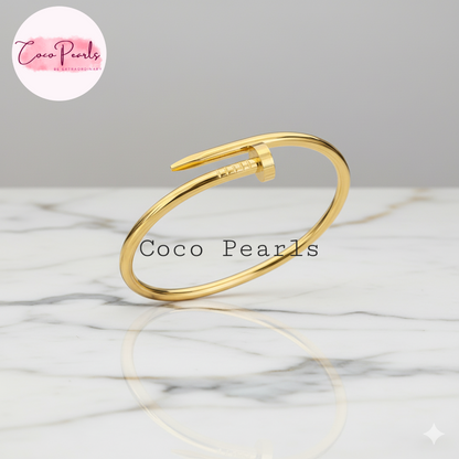 Coco Pearls Stainless Steel Anti Tarnish Gold sleek nail handcuff bracelet on a marble surface