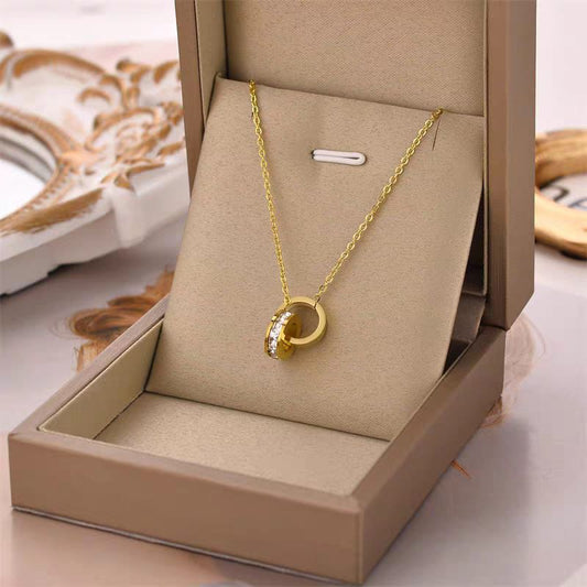 Coco Peals Stainless Steel anti  tarnish Gold sparkle loop bracelet with a circular pendant in an open jewelry box on a decorative surface.
